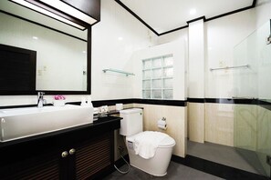 A modern bathroom with a large mirror, a sink, a toilet, and a glass shower enclosure. - Baan Narakorn Private Pool (Krabi)