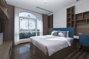 A modern bedroom with a large bed, a view through a window, built-in shelving, and a blue chair.