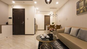 A modern living room with a sofa, a round coffee table, and a dining area in the background.