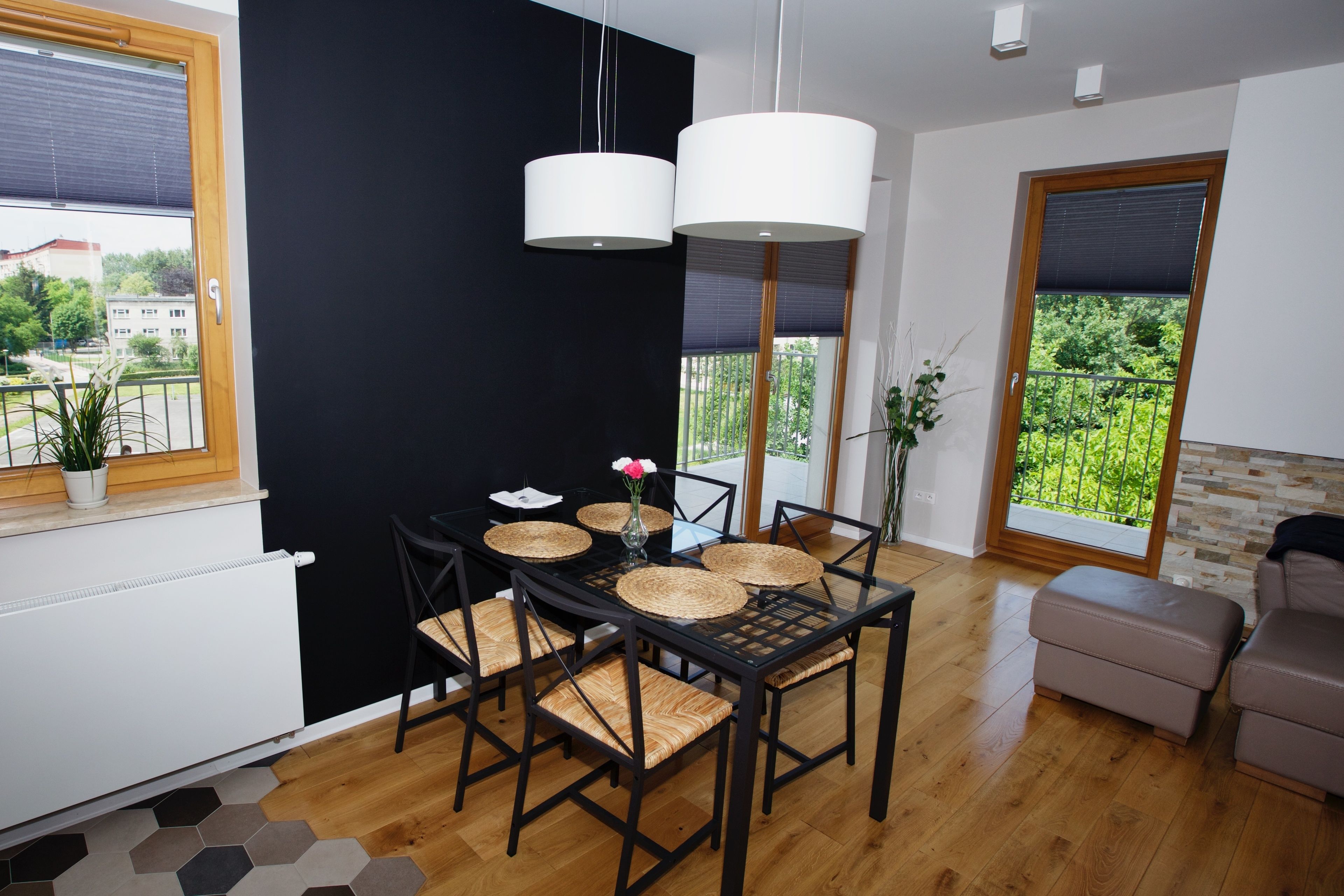 Un comedor moderno con una mesa negra, individuales tejidos y sillas negras.
