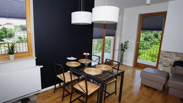 Un comedor moderno con una mesa negra, individuales tejidos y sillas negras.