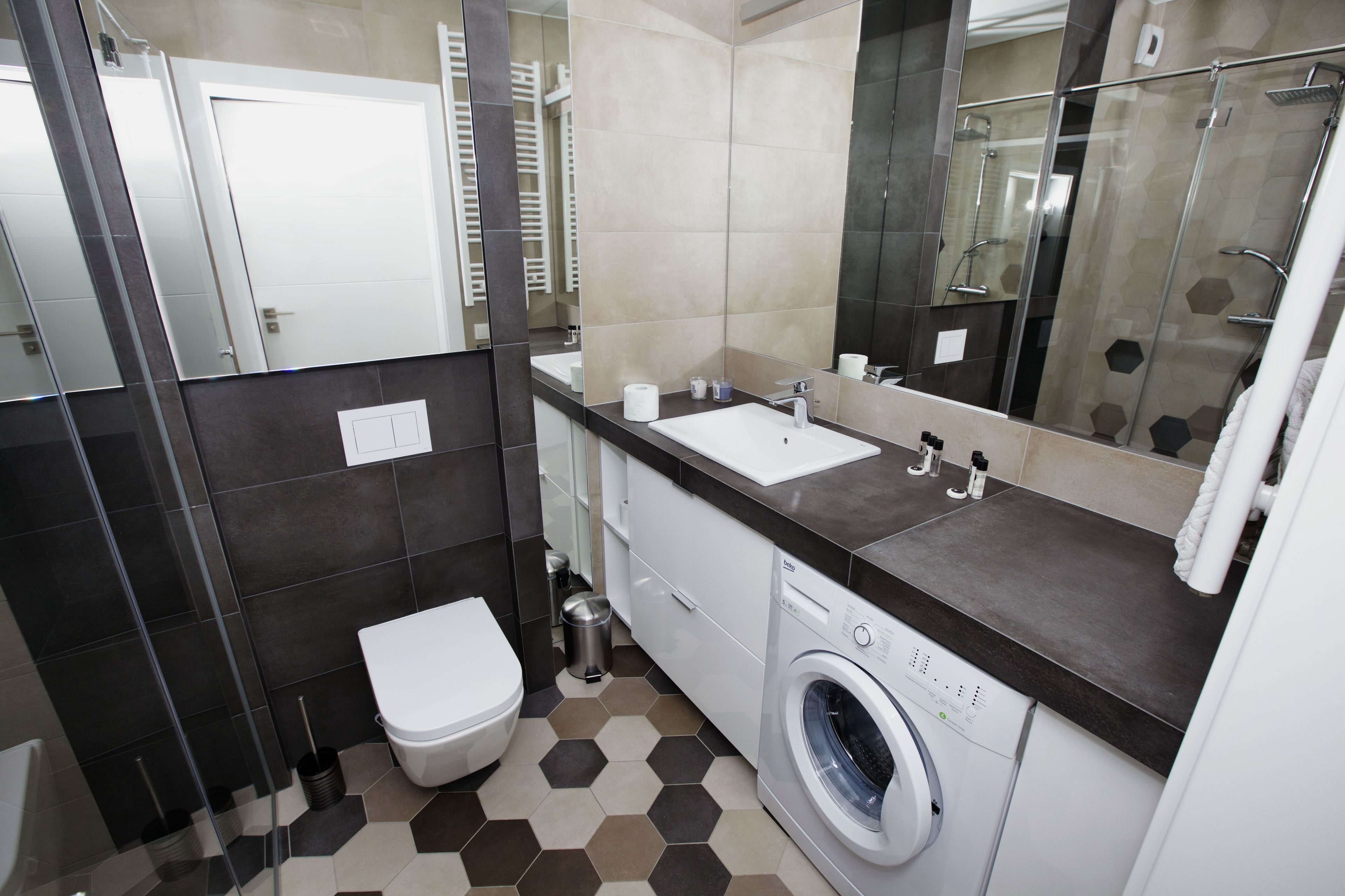 A modern bathroom with a toilet, sink, and washing machine.
