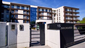A modern apartment building with multiple balconies and a gated entrance. - City of the Kings Green Silence Apartment (Kraków)