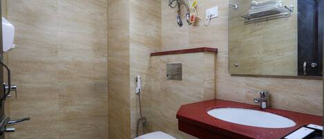 A bathroom with a white toilet, a red sink, and a mirror above the sink.
