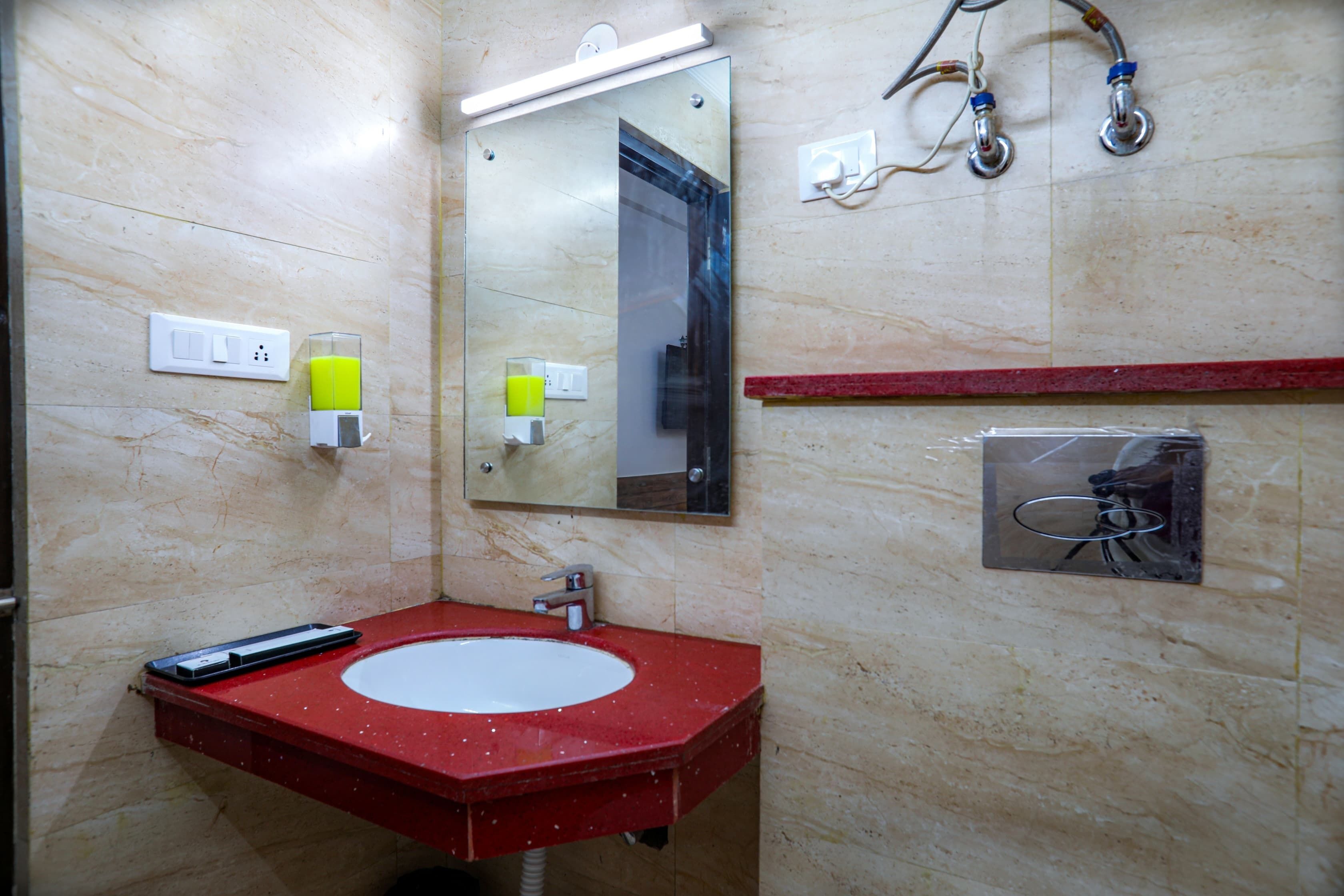 Une salle de bain avec un lavabo rouge, un miroir et un porte-serviettes.