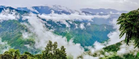 Un paysage montagneux, caractérisé par une végétation luxuriante et des nuages.