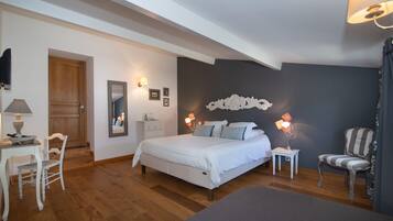 A bedroom with a bed, bedside tables, a chair, a desk, and a mirror.