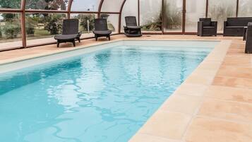 Relax by the pool with a serene view of the surrounding landscape.