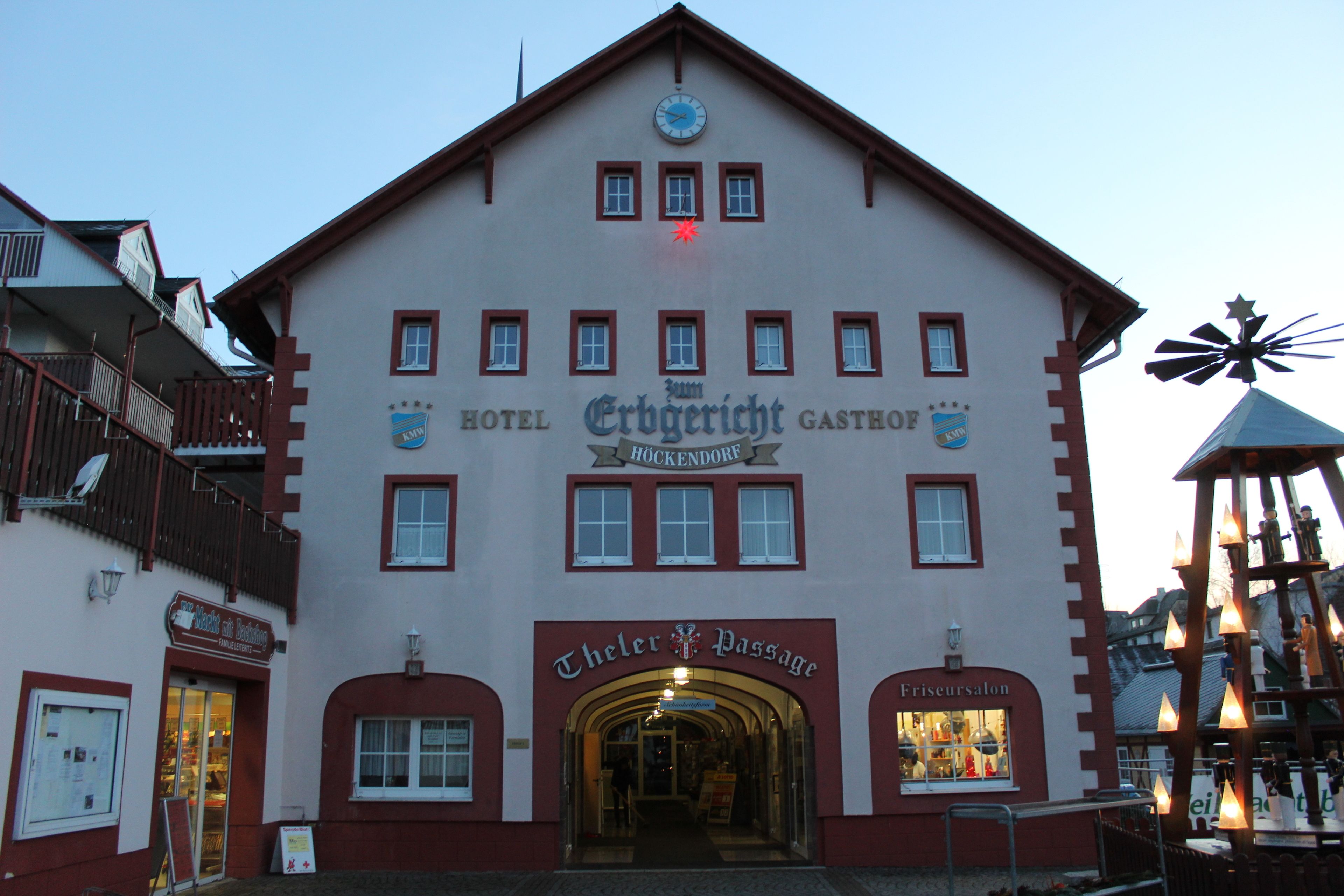 Ein Gebäude mit mehreren Schildern, darunter 'Hotel Erbgerecht' und 'Theler Passage'.