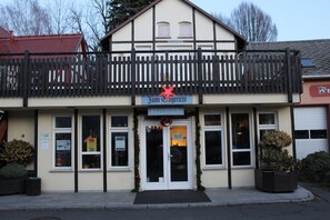 A building with a reception area, a balcony with a railing, and a sign that reads "JUN & Co. Reception". - Hotel Zum Erbgericht (Klingenberg)