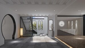 A modern hotel lobby with a staircase, a reception desk, and a large window with a view of greenery. - Suzhou Cloud Art Inn (Suzhou)