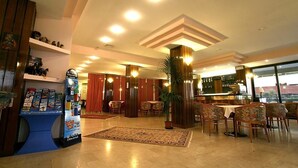 A hotel lobby with a bar area, seating, and a reception desk. - Hotel Avila In (Rimini)