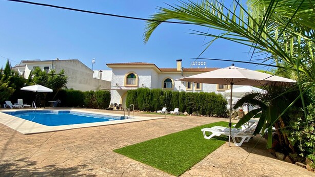 Una piscina al aire libre de temporada, sombrillas