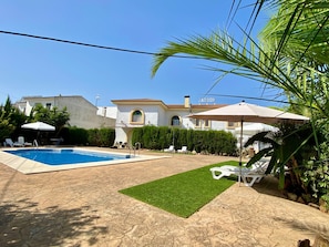 Una piscina al aire libre de temporada, sombrillas