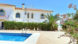 Una piscina al aire libre de temporada, sombrillas