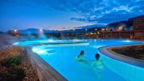 A swimming pool with a view of mountains at dusk. - Pod Tatrami (Bukowina Tatrzanska)