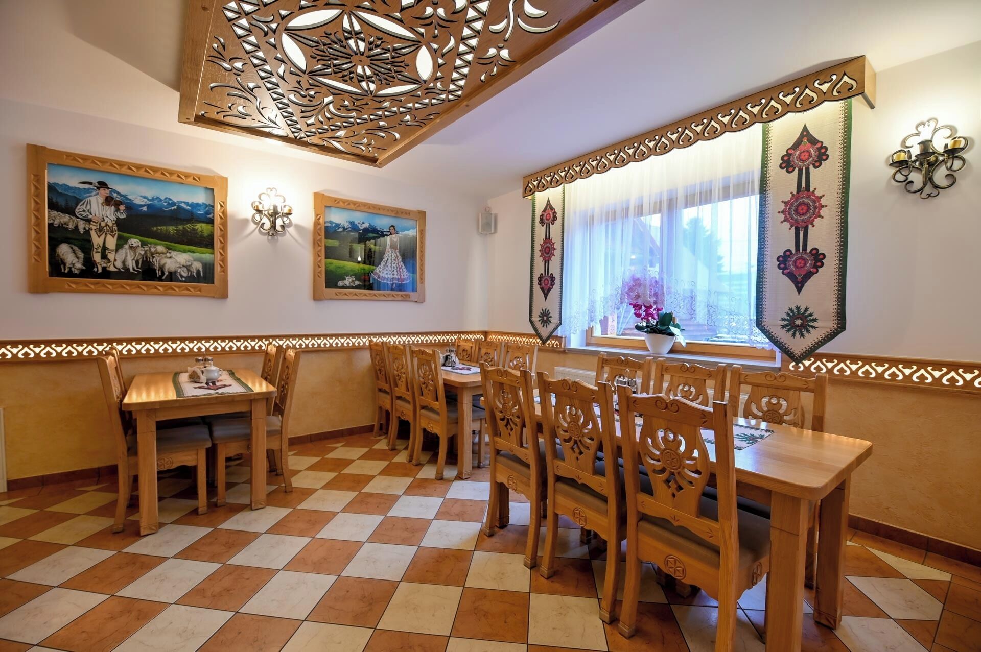 A dining area with wooden furniture, patterned wall decorations, and artwork.