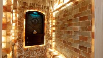 A stone-walled room with a wooden floor and a window featuring a circular emblem.