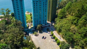 Ein Hochhauskomplex mit Parkplatz und Blick auf das Meer.