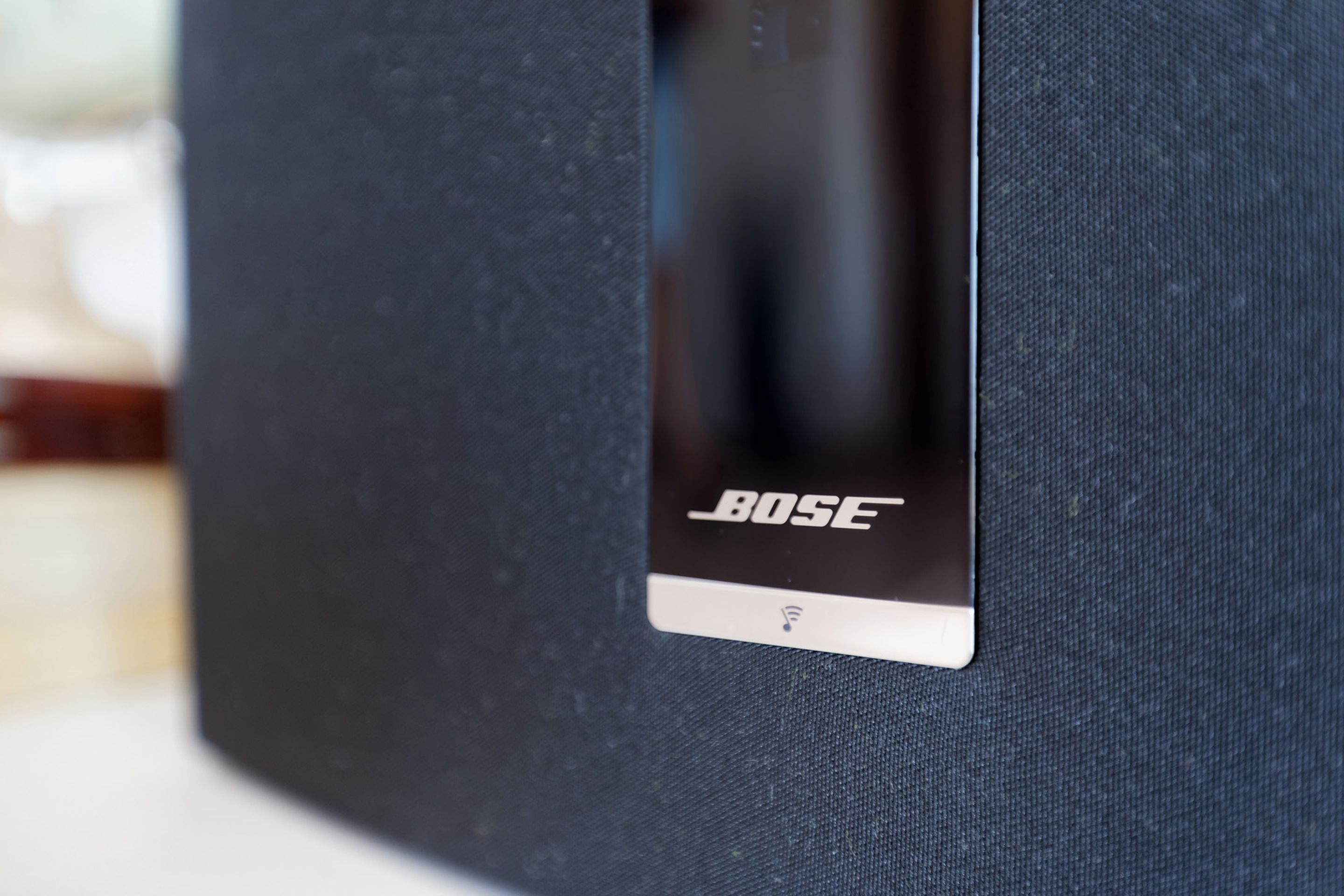 Et nærbillede af en sort højttaler, hvor mærket "BOSE" er synligt på fronten.