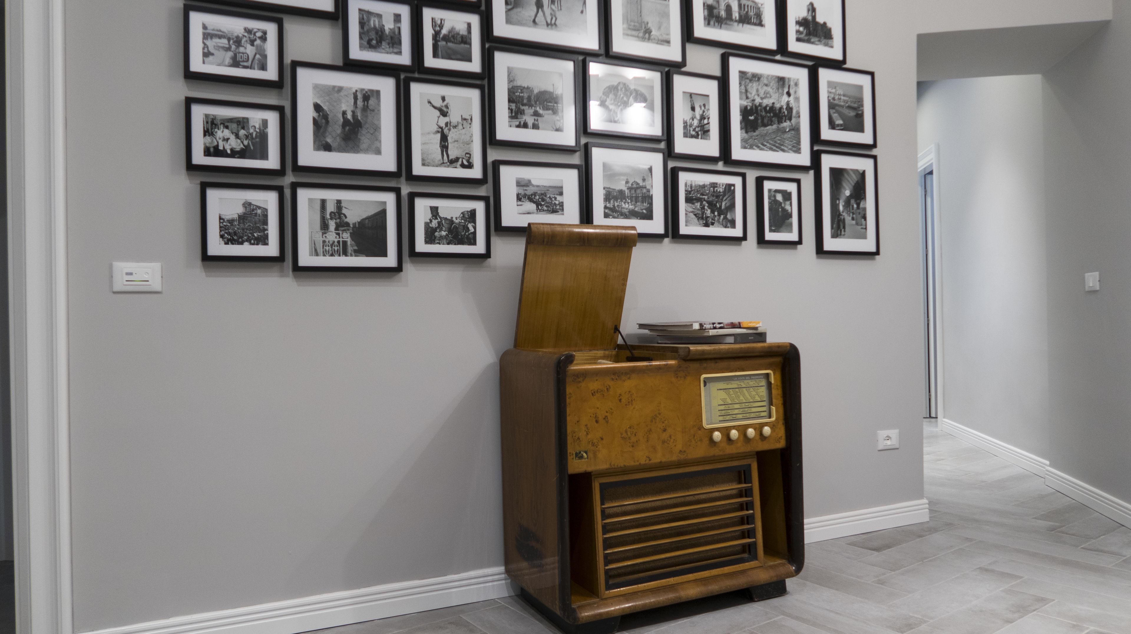Ein Flur mit einer Wand voller gerahmter Schwarz-Weiß-Fotos und einem alten Radio.