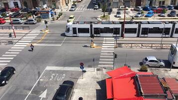 Vista da rua com um eléctrico, carros e uma passadeira pedonal.
