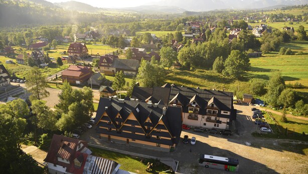 Un pueblo europeo tradicional con un edificio destacado, techo empinado y un patio central.