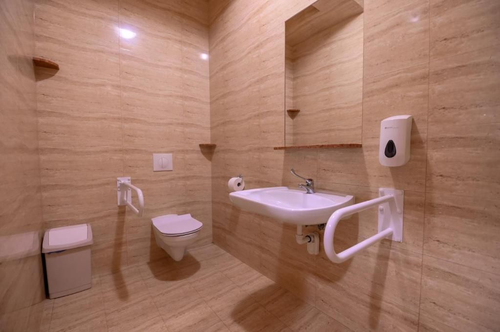Ein Badezimmer mit Toilette, Waschbecken und Handtrockner.