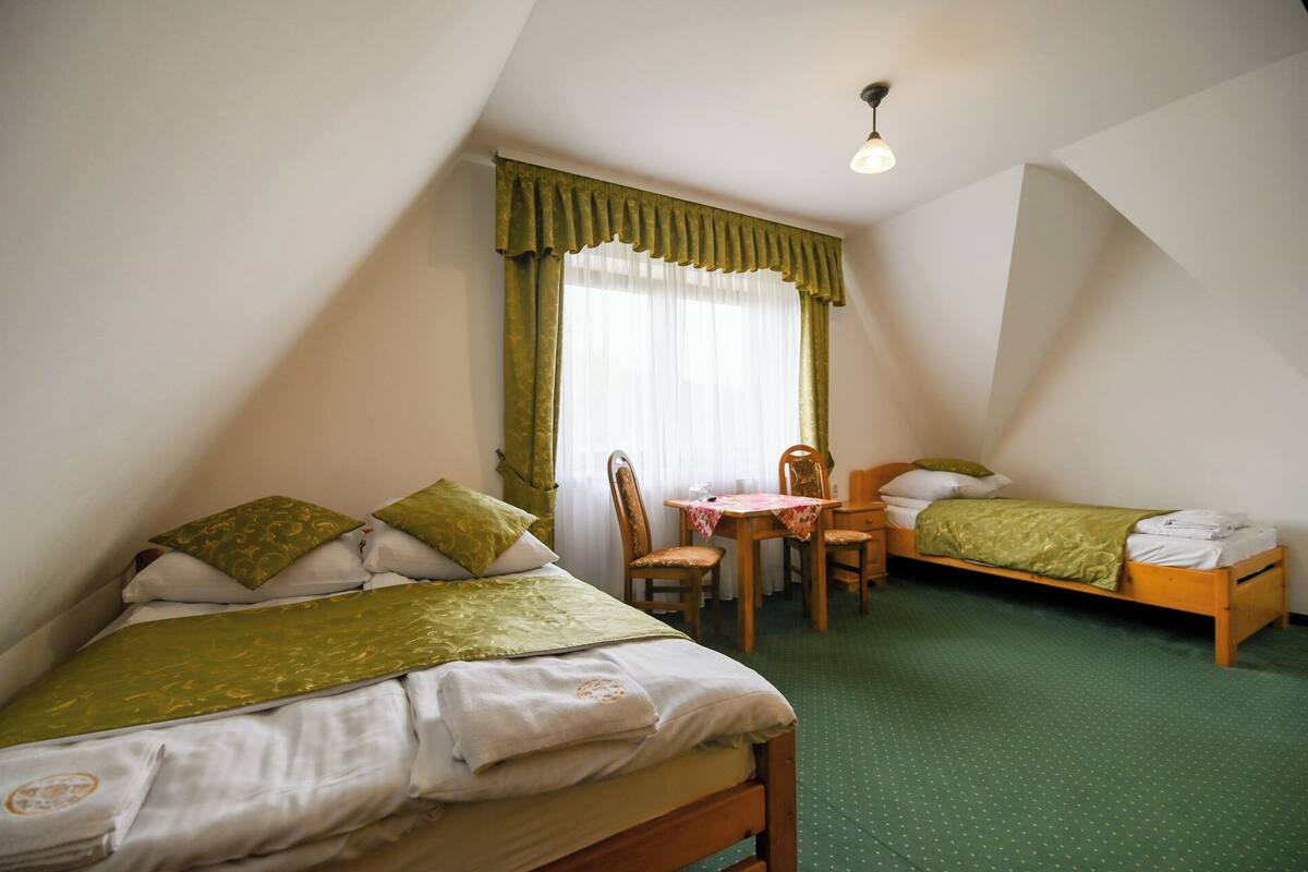 Une chambre avec deux lits, une table à manger et une chaise.