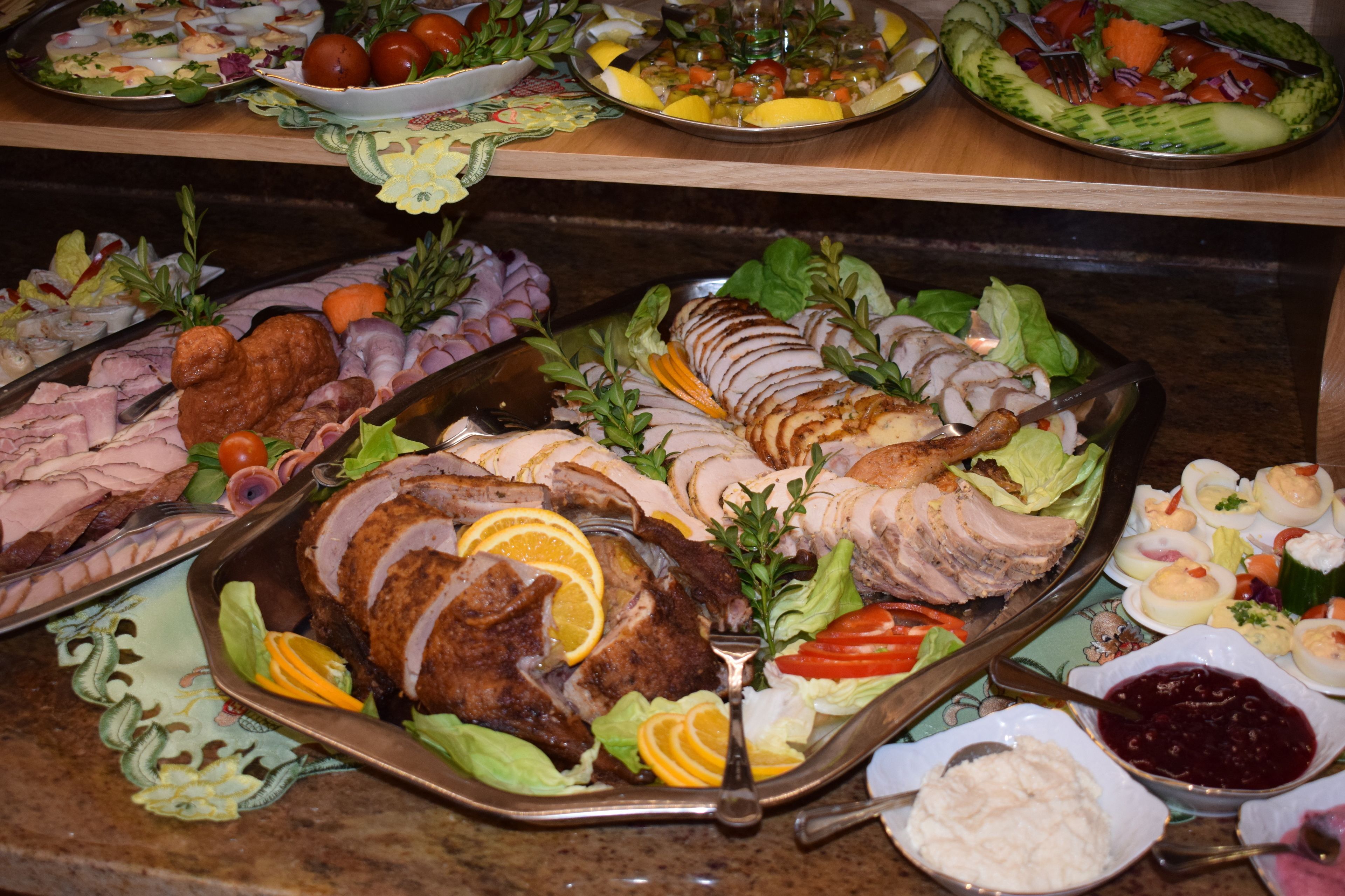 Un bufé con diversos platos, incluyendo carnes en rodajas, ensaladas y guarniciones.