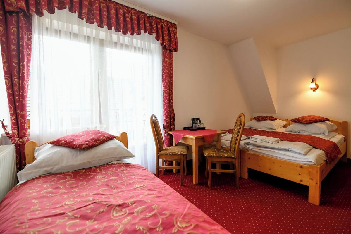 Une chambre à coucher avec un lit, un bureau et deux chaises.