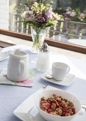 A breakfast table with a pitcher, salt shaker, cups, and a bowl of cereal. - Pension Haus Brieden (Winterberg)