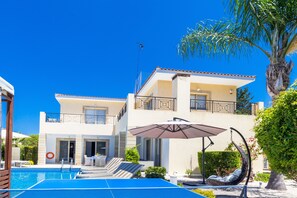 A two-story building with a swimming pool, outdoor seating, and a hanging chair. - Villa Chiara (Kissonerga)