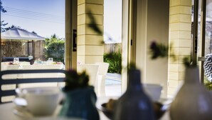 A dining area with a table set for two, a chair, and a vase. - Villa Chiara (Kissonerga)