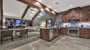 Une cuisine moderne avec des meubles en bois, des appareils électroménagers en acier inoxydable et un grand îlot central.