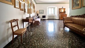 Un salon spacieux avec un plancher ciré, un canapé, un fauteuil et une table.