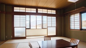 Une pièce de style japonais traditionnel, avec un sol recouvert de tatamis, une table en bois et des paravents en papier.