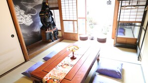 Um quarto japonês tradicional, com tatames no chão, uma mesa de madeira baixa e uma porta de papel shoji.