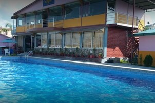 Un edificio con piscina, balcón y escalera.
