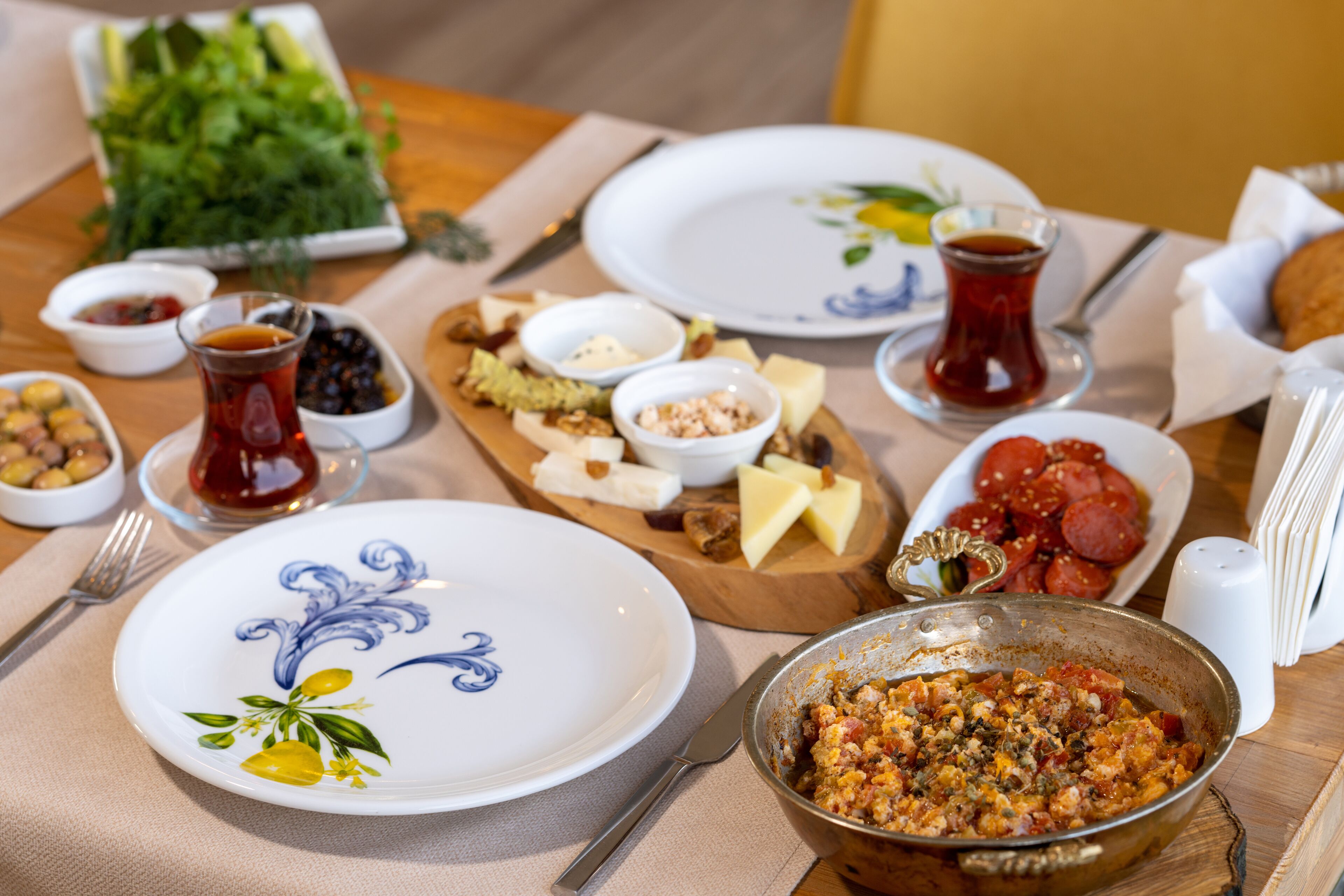 Una mesa de comedor con varios platos, incluyendo un tazón de ensalada, queso, nueces y un tazón de sopa.