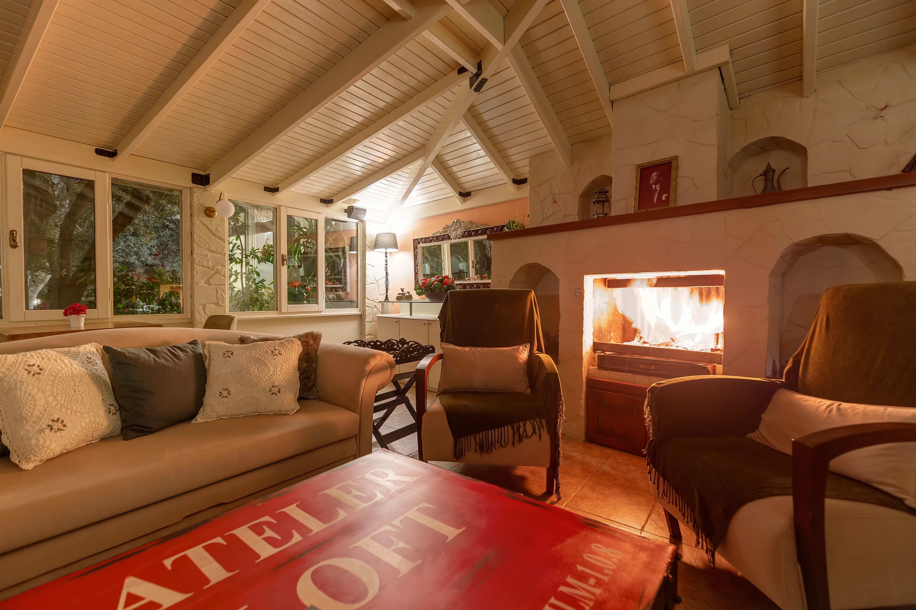 A cozy living room with a high ceiling, a fireplace, a sofa, and a coffee table.