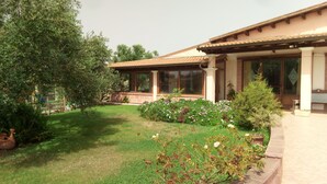 A house with a garden, a pergola, and a patio area. - Agriturismo Is Scalas (Assemini)