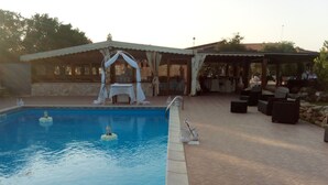 A swimming pool with a small island and a gazebo. - Agriturismo Is Scalas (Assemini)