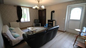 Una sala de estar con un sofá, una mesita, un televisor y una chimenea.