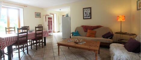 Una sala de estar con una mesa de comedor, sillas, un sofá y una mesa de centro.