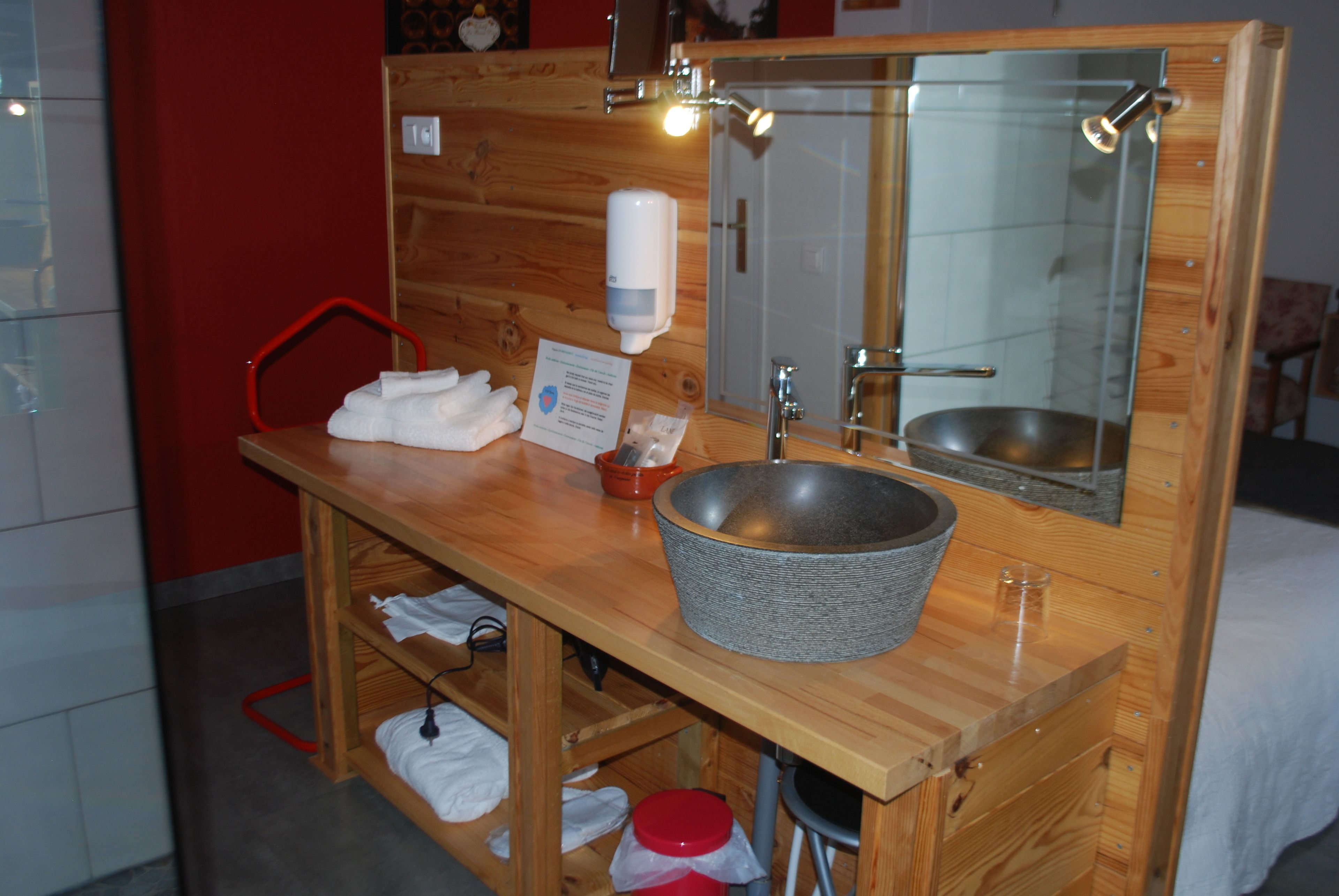 A wooden vanity with a large mirror, a sink, and a towel rack.