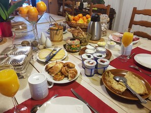 Taula de l'esmorzar amb diferents aliments, com ara pastissos, fruita i begudes.