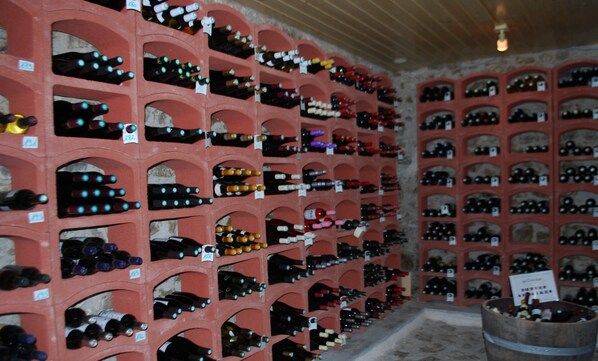 A wine cellar with rows of wine bottles on shelves. - Le Ranch des Lacs, Hôtel Restaurant à Augne (Augne)