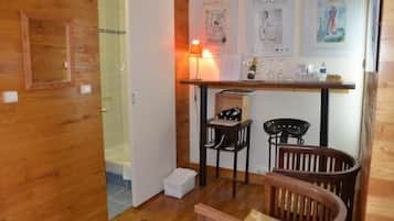 Cozy retreat with a seating area, wall-mounted lamp, and enclosed shower.