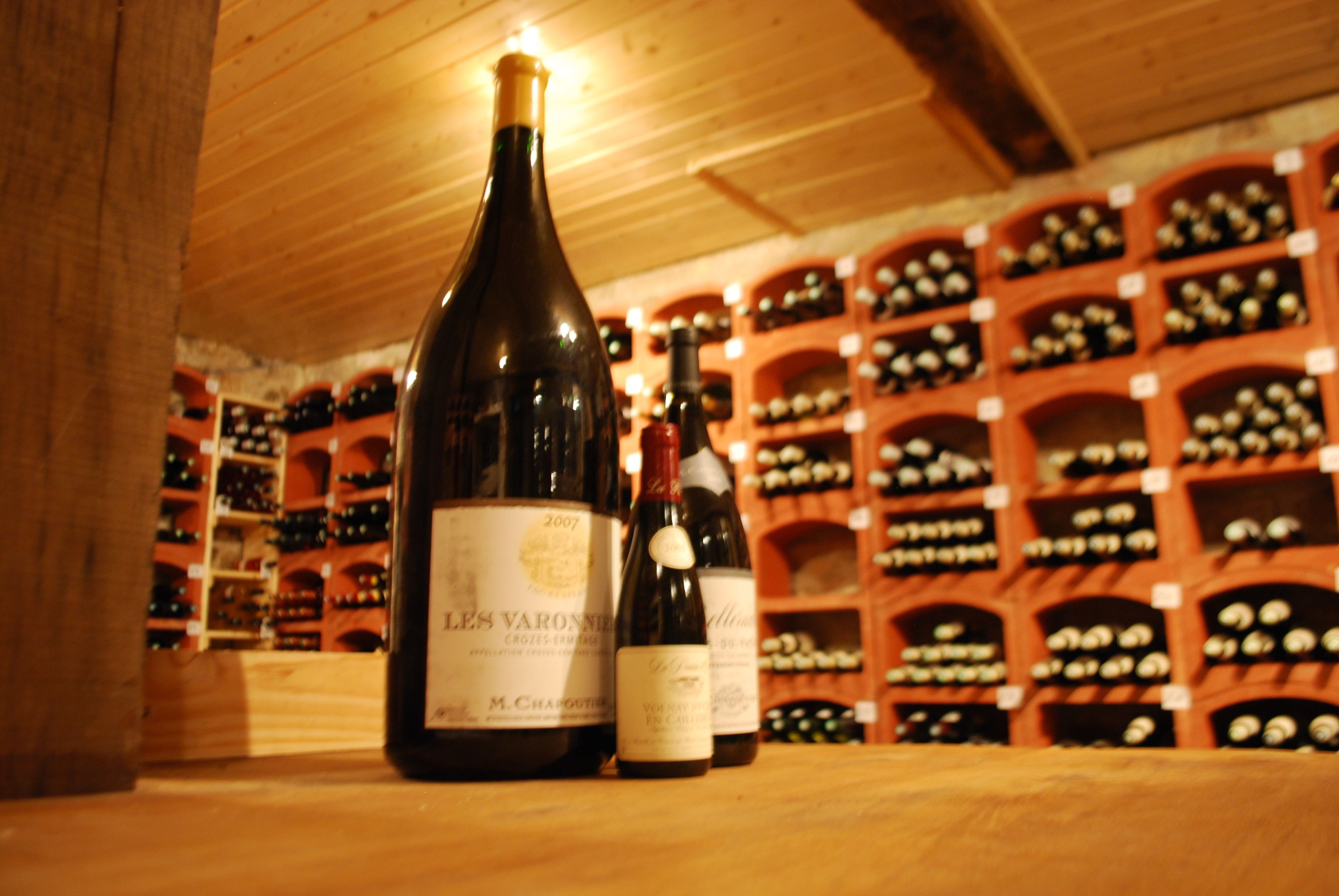 Una bodega con estantes de madera y botellas de vino.